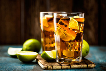 Cuba Libre or long island iced tea cocktail with strong drinks, cola, lime and ice in glass, cold longdrink