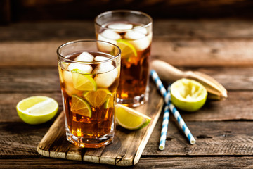 Cuba Libre or long island iced tea cocktail with strong drinks, cola, lime and ice in glass, cold longdrink