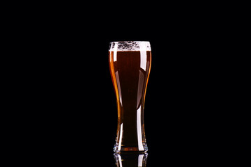 Beer glass with foam on black background