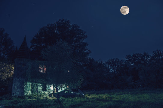 Night landscape of green meadow with trees and mysterious medieval castle in a full moon night. Azerbaijan Nabran