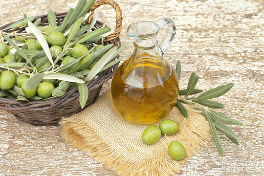 Olives with leaves and jug of olives oil 