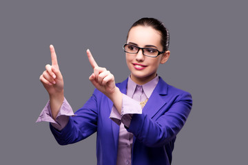 Businesswoman pressing virtual button on gray background