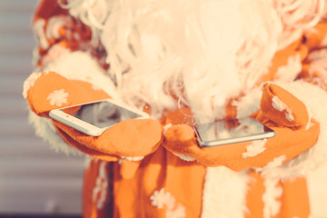 Busy Santa Claus using mobile device, closeup on hands