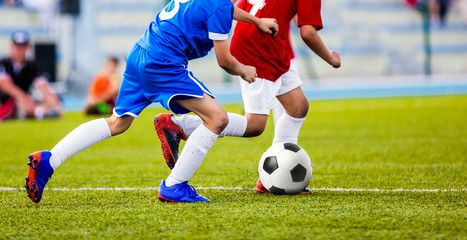Football Match for Children. Kids Playing Soccer Tournament Game. Boys Running and Kicking Football on the Sports Field. Two Youth Soccer Players Compete for the Soccer Ball