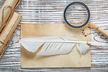 Old sheet corded paper roll feather magnifying glass on vintage 