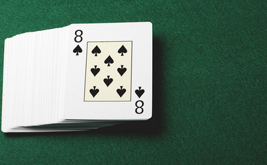 Deck of poker cards on green background. Horizontal shoot.