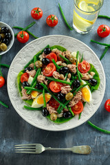Fresh Tuna Green Bean salad with eggs, tomatoes, beans, olives on white plate. concept healthy food