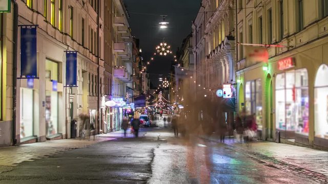People walking by on city street with Christmas decorations Time Lapse. Stockholm city at night