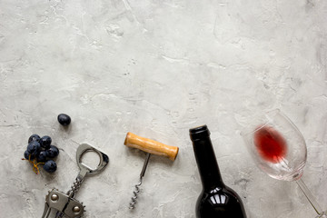 bottle of red wine and corkscrew on stone background top view mockup