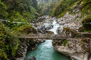 Old wooden bridge on the mountain river Myagdi in Dhaulagiri region, Nepal.