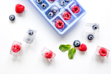 tray with berries ice cubes on white background top view