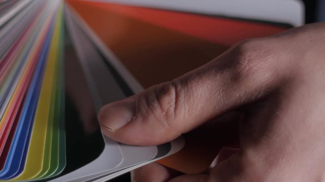 Color sampler for exterior vinyl siding isolated on black, desinger hands