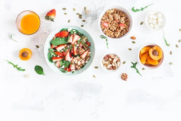 Photo sur Plexiglas Manger Petit déjeuner avec muesli, salade de fraises, fruits frais, noix sur fond blanc. Concept d& 39 alimentation saine. Mise à plat, vue de dessus