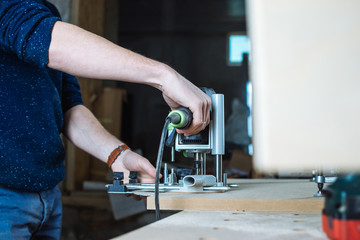 Young man working as carpenter and cutting board