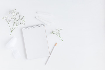 Workspace with notebook, paper blank, gypsophila flowers, pencils. Wedding concept. Flat lay, top view