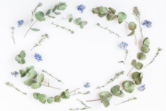 Flowers composition. Frame made of dried flowers and eucalyptus branches on white background. Flat lay, top view