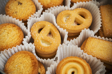 set of fresh cookies in a beautiful curly packaging on a wooden background.