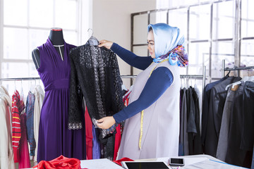 Fashion designer holds clothes