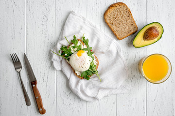 sandwich with poached eggs on wooden background top view