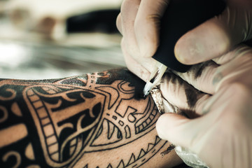 Master tattoo artist in gloves makes tattoo on hand men