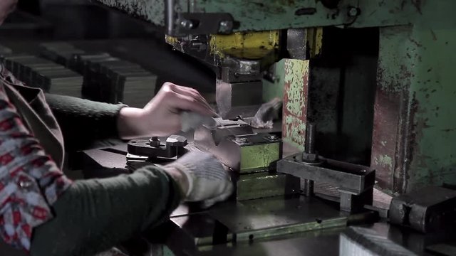 Hands of a woman working in the factory making fasteners