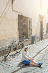 Young female traveler sitting with bicycle