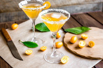 cocktail with kumquat on wooden background