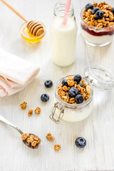 Fitness breakfast with granola, milk and honey on white background