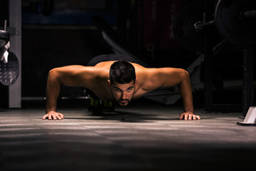 Fototapeta na wymiar Young man is exercising in the gym doing push-ups.