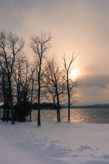 sun setting over lake in winter 
