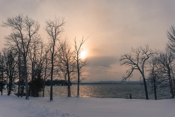 sun setting over lake in winter 
