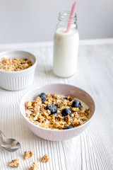 Homemade fitness granola with yoghurt and berries on white kitchen background