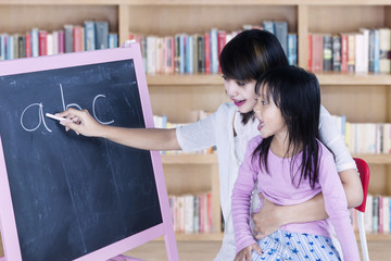 Girl learns alphabet with teacher