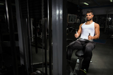 Fototapeta na wymiar Handsome young man is exercising at the gym