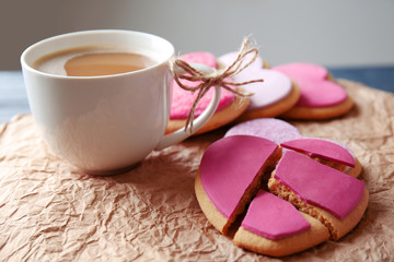 Heart shaped cookies with cup of coffee and parchment, closeup