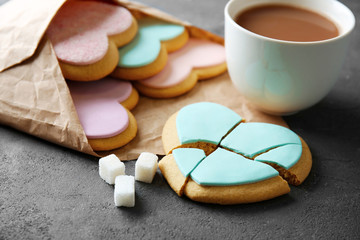 Heart shaped cookies with cup of coffee and parchment on grey background, closeup