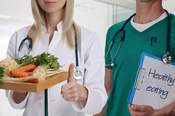 Healthy eating concept . Doctor holding plate with fresh vegetables and showing thumbs up