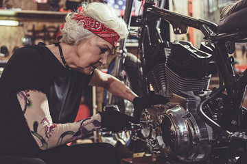 Obraz na płótnie Canvas Serene female retiree reconditioning vehicle in garage