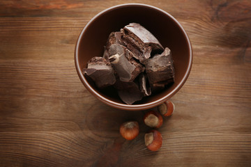 Broken chocolate pieces in bowl, close up