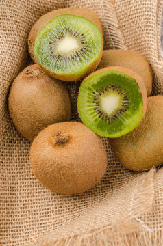 Box of fresh kiwi in on wooden background.