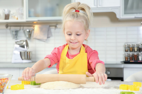 Cute little girl making dough for Easter cookies