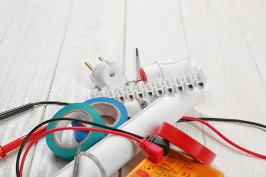 Electrician tools on white wooden background