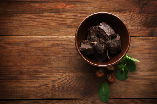 Broken chocolate pieces in bowl, close up