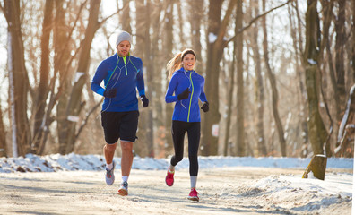 Paar in de winter samen rennen in de natuur