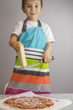 Boy is prepearing pizza