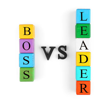 Towers of colorful wooden cubes and black letters forming text BOSS VS LEADER isolated on white