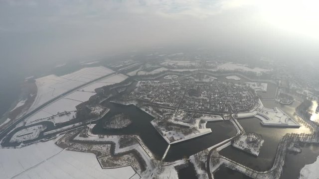 Aerial bird view of Naarden vesting during winter time showing snowy environment Naarden is an example of star fort complete with restored fortified walls and moat great contrast due to white snow 4k