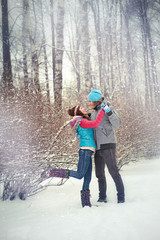 Girl and man play in the snow