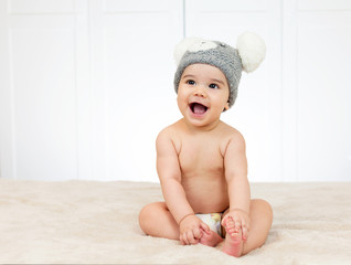 Beautiful baby boy in bed with a funny hat