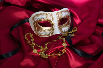 Gold and White Mask on Red Satin with Gold Mardi Gras Necklace